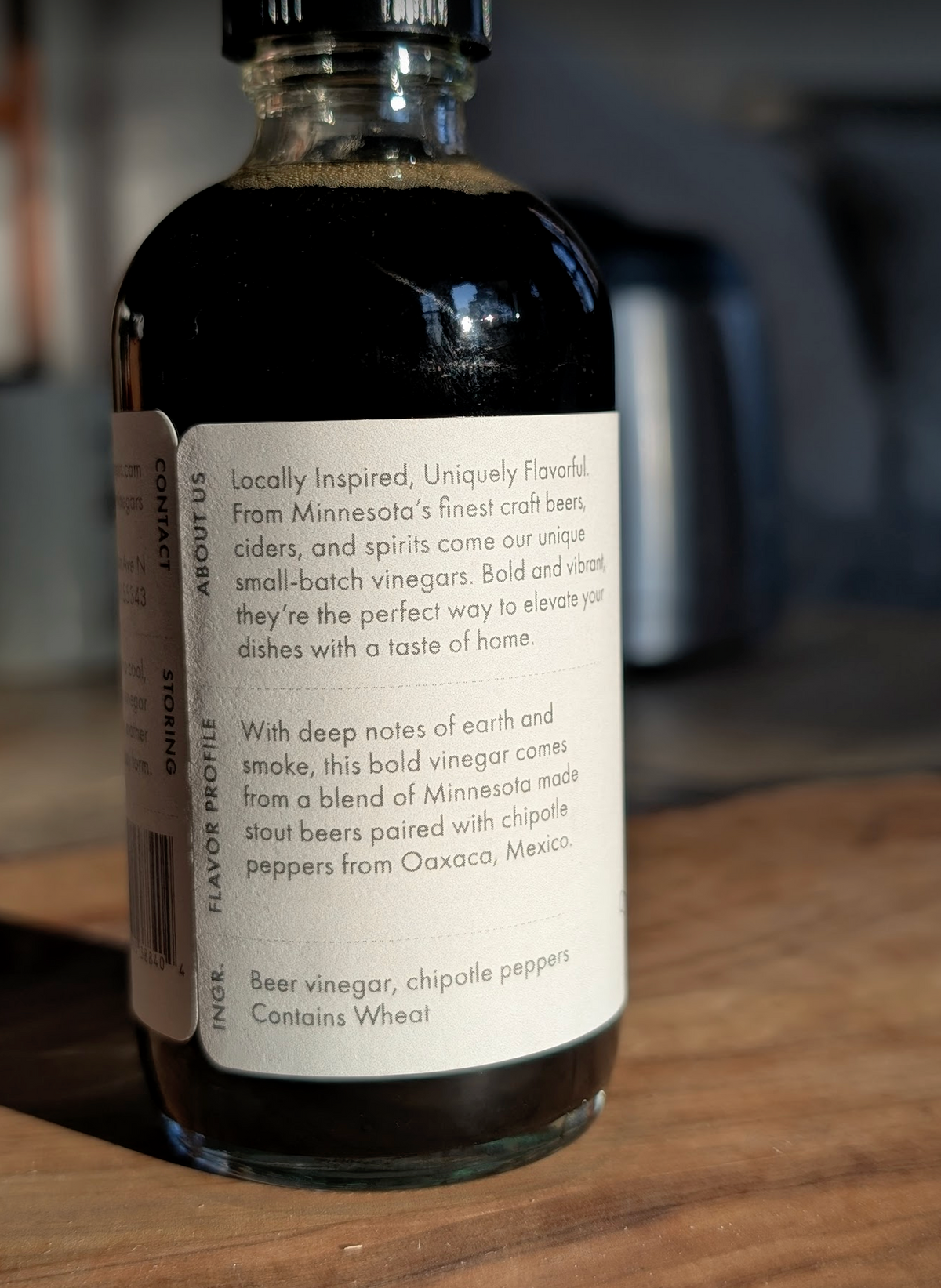 Bottle of beer vinegar with a label on a wooden surface